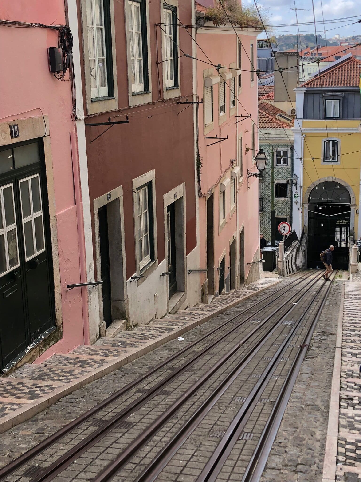 Street with funicular rails and pastel houses in Lisbon
