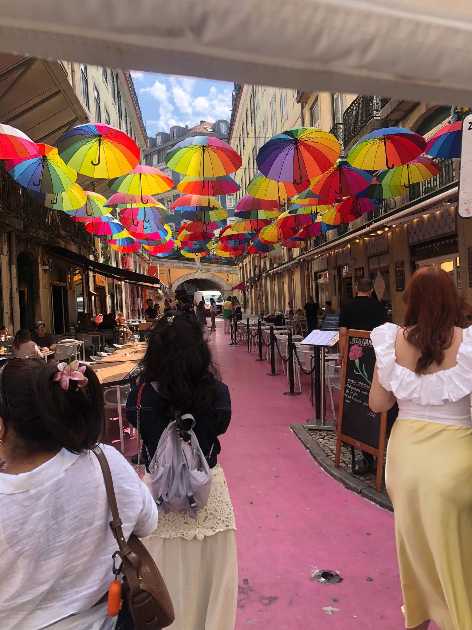 Colorful umbrellas hanging above a Lisbon street